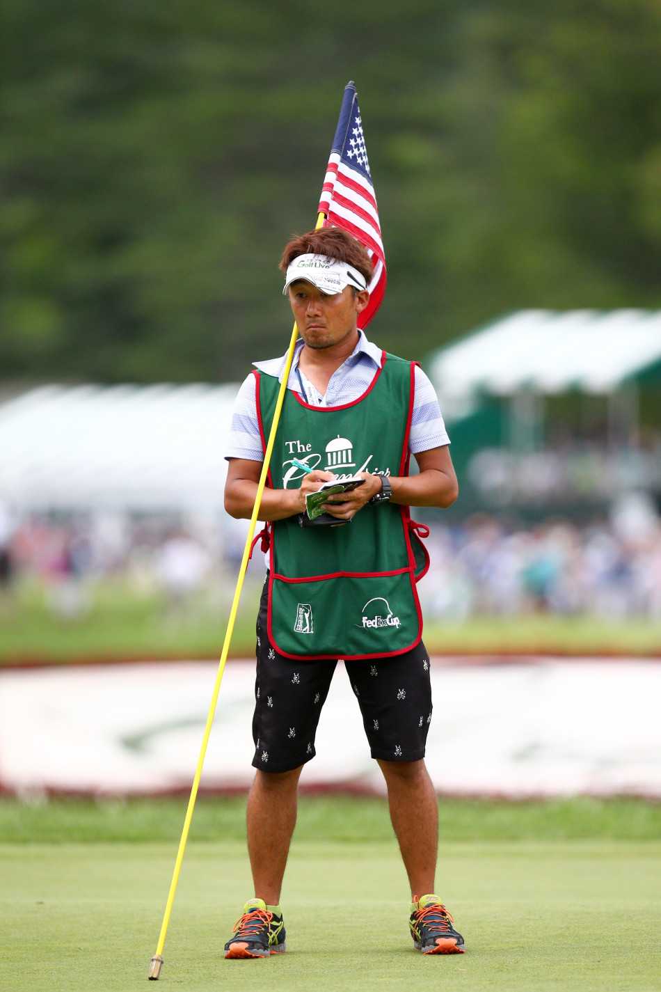 卫兵双手稳稳持握竖立的旗杆，身姿挺拔如松，背景是开阔的高尔夫球场，展现出力量与守护的意象。