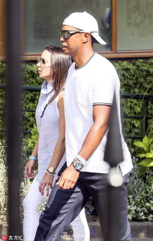 老虎伍兹反戴一顶黑色帽子，目光锐利地望向赛场远方，休闲中透着不凡的巨星气场