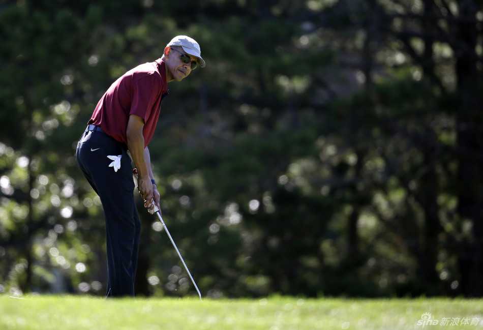 奥巴马在果岭上优雅推杆，球杆与身体形成一条流畅的弧线，尽显运动中的从容。