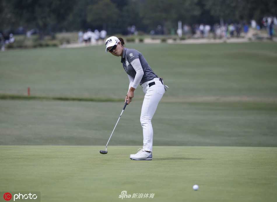 李旻智挥杆瞬间，身姿矫健有力，阳光下拉出长长的身影。