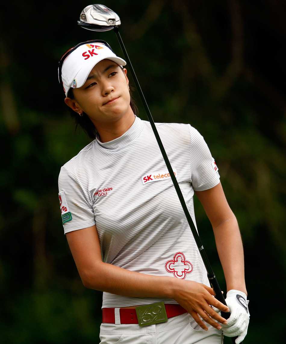 崔罗莲在比赛中优雅推杆，身体线条舒展如画，周围的观众屏息凝神等待小白球进洞的瞬间。