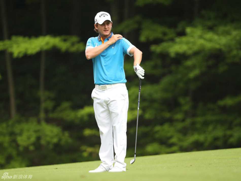 埃米利亚诺·格里洛扬起手臂向远方示意，身后是沐浴在金色光线中的广阔球场