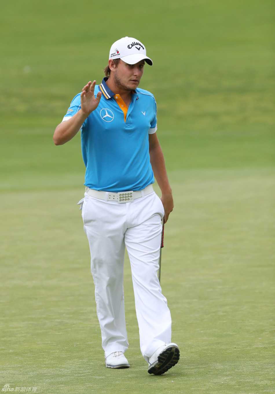 加里·伍德兰德单膝跪地仔细阅读果岭纹理，指尖几乎触到草叶，仿佛在聆听大地的细微低语