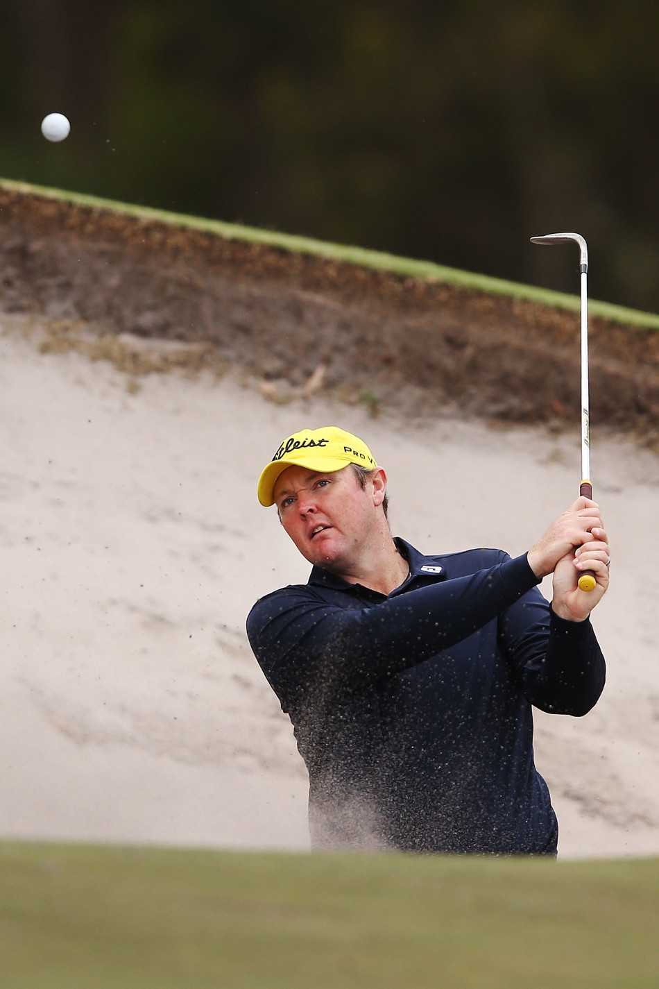 两支大小悬殊的高尔夫推杆并排靠在墙边，旁边散落着儿童手套和彩色高尔夫球