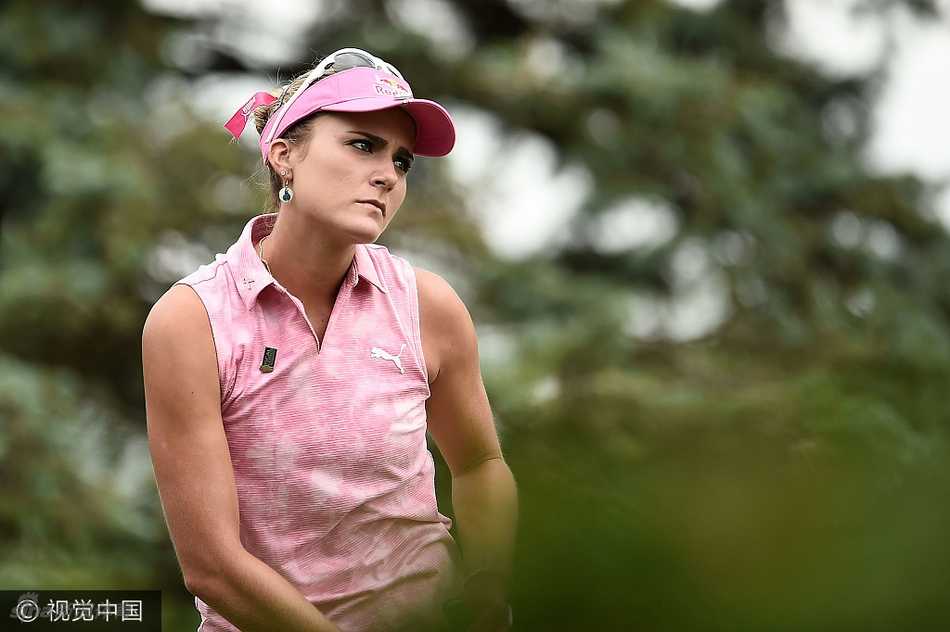 莱克西·汤普森在果岭旁专注观察推杆线路，神情坚定