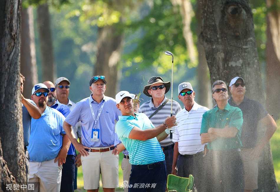 一名球员在沙坑中救球，沙尘微微扬起，展现了高尔夫比赛中挑战性的一面。