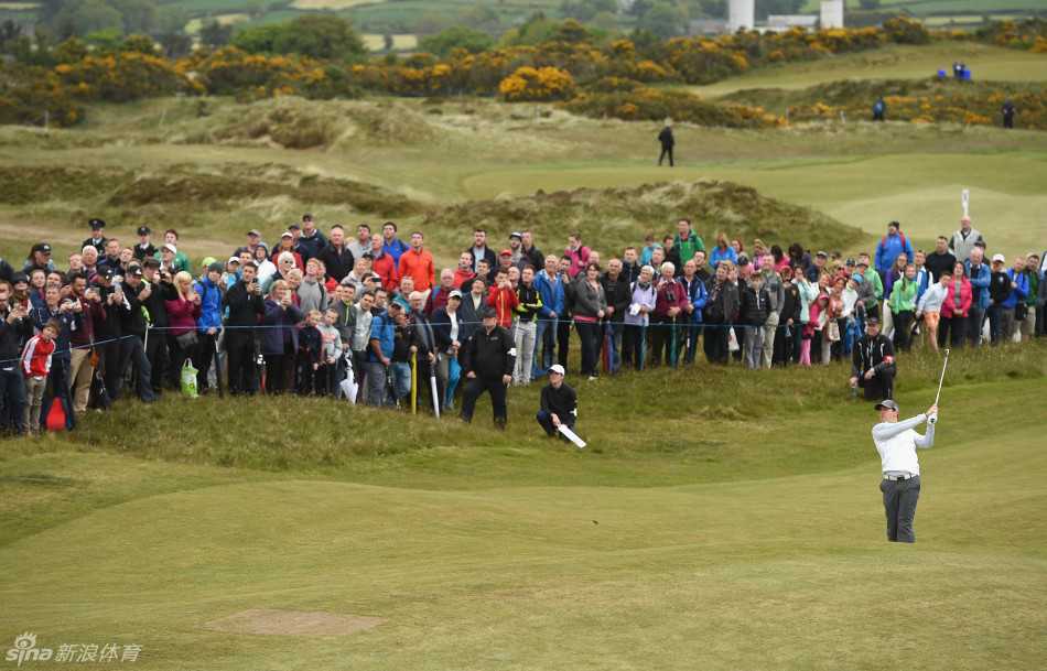 细雨中的优雅身姿：麦克罗伊撑伞漫步于练习场，神情专注，即将投入训练。