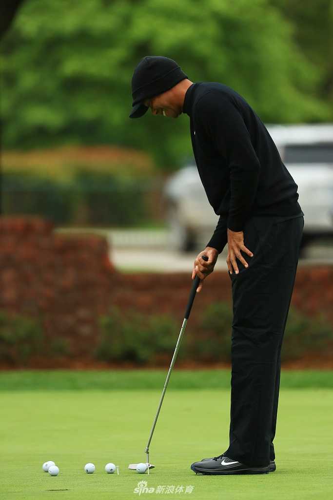 伍兹与球童深入探讨，手指远方球道，布局攻克艰难赛场的策略