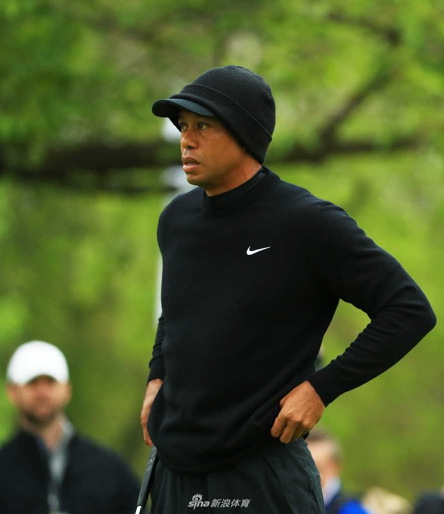 夕阳下的泰格伍兹收拾球包，身影与金色球场融为一体，蓄势待发