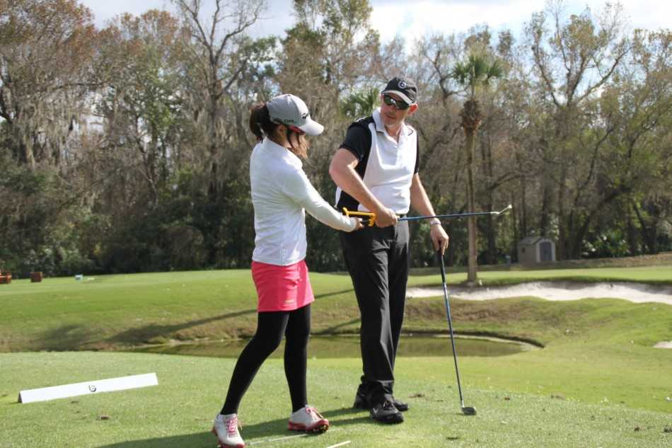 学员郭婉仪在教练Scott的实时指导下进行击球练习，她的眼神紧随空中飞行的白色小球，脸上露出专注与思索的神情