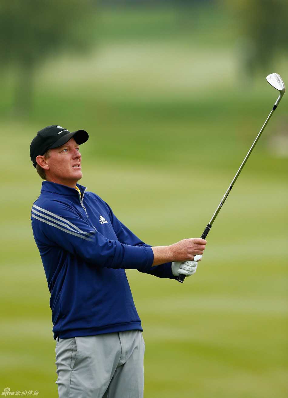 球员大卫·霍希在果岭上俯身进行推杆，他的动作稳定而专注，力求将小球沿着预判的线路送入洞中，完成比赛的最后一击。