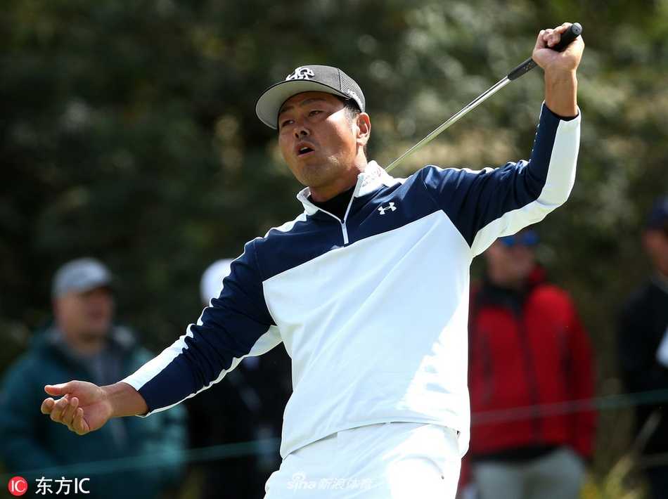 高尔夫球落在沙坑边缘的挑战位置，沙坑耙出的纹理与草皮绿茵形成鲜明对比