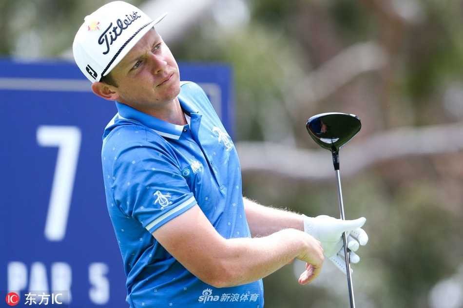 球员在果岭上俯身仔细查看推杆线路，手套还插在口袋中，神情专注而认真