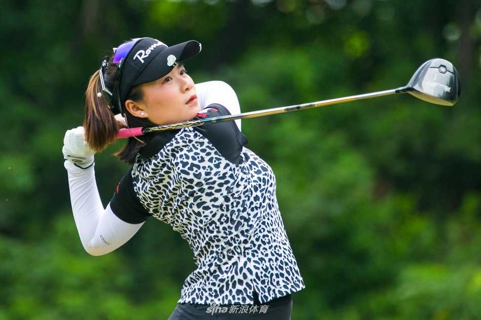 黄靖与球童并肩而立，奖杯熠熠生辉，共庆团队胜利