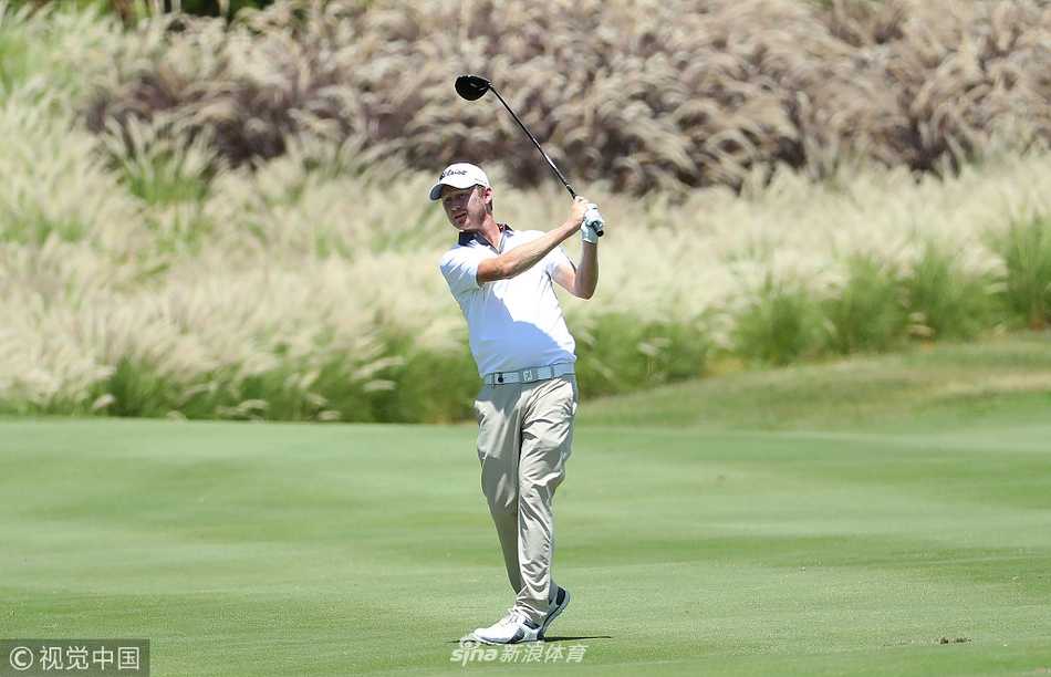 毛里求斯公开赛次轮，球手在蔚蓝水障碍旁的球位谨慎处理击球，画面充满戏剧性与挑战性