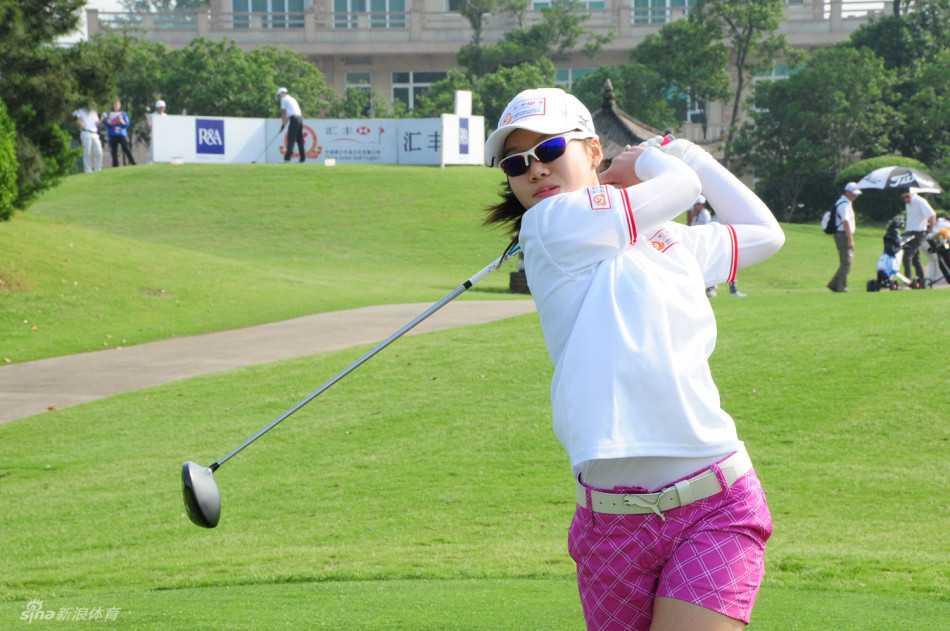 卢靖雯在银杏湖球场果岭边凝神观察推杆线路，阳光洒在稚嫩而专注的脸庞上。