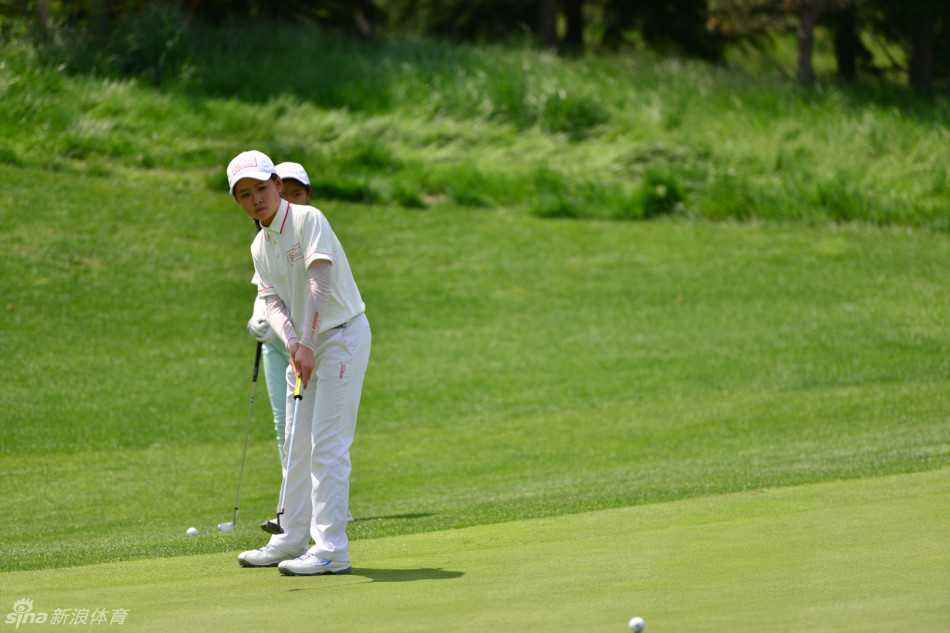 青少年冠军球员王鑫兴手持奖杯笑容灿烂，身后是广阔的球场，象征着他通过努力赢得的广阔未来。