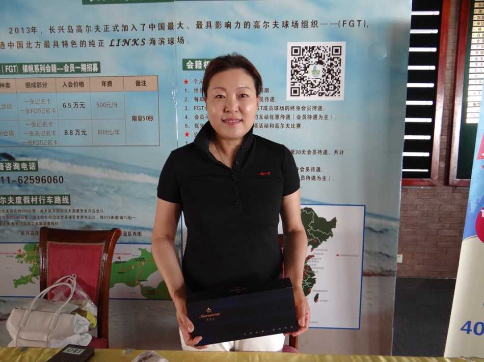 活动颁奖时刻，获奖球手高兴地举起芙蓉王礼盒，与同伴共同庆祝这一荣耀瞬间，身后是广阔无垠的球场美景。