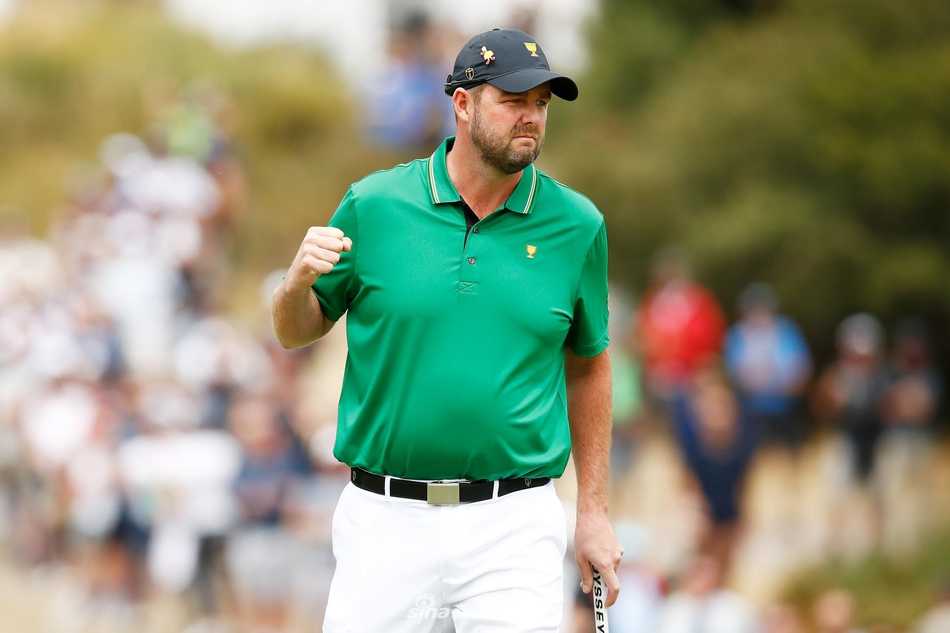 帕特里克·坎特利在第十八洞果岭握拳庆祝，他刚推入制胜小鸟推，身后是欢呼的队友