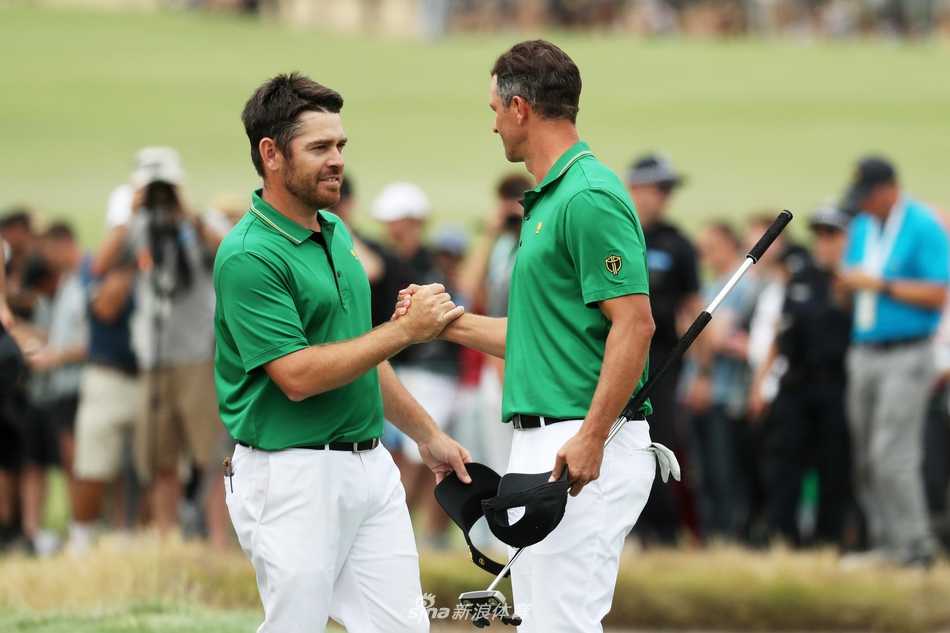 贾斯汀·托马斯推入致胜推杆后，与老虎伍兹激情相拥庆祝，背景是皇家墨尔本的会所