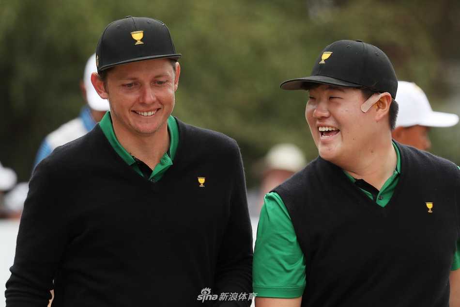 任成宰与卡梅隆·史密斯在果岭上查看推杆线路，两人首次总统杯搭档表现亮眼