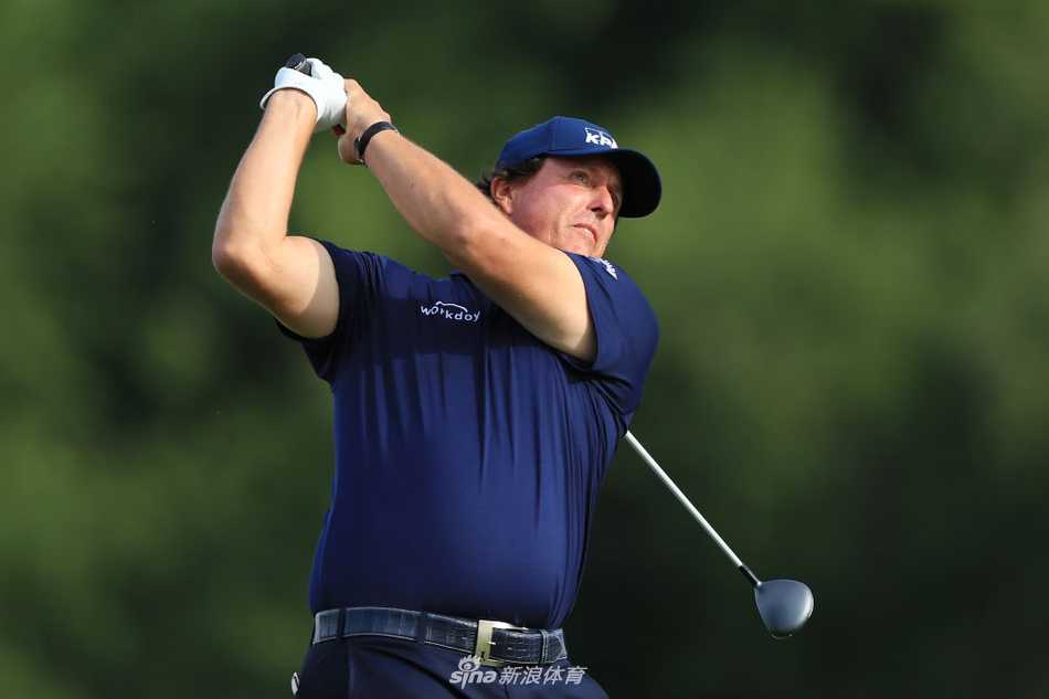 松山英树在果岭上弯腰仔细阅读推杆线路，表情冷静沉着，展现亚洲一哥的风范