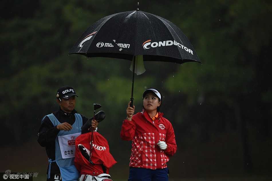 石昱婷站在果岭边微微低头，神情专注地观察球路与草纹，为推杆做最后准备