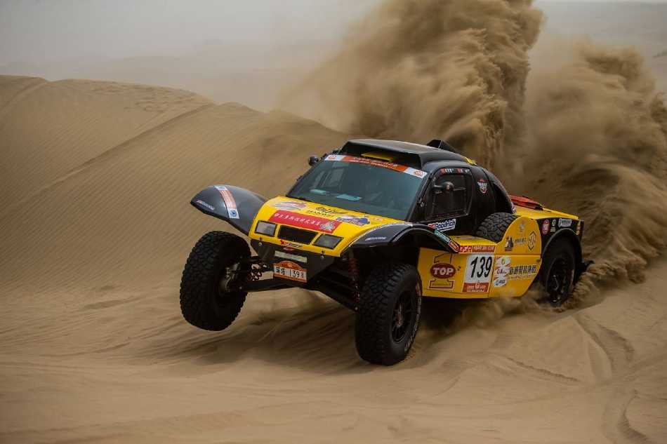 摩托车手驾驭铁骑从陡峭沙坡俯冲而下，身后扬起滚滚沙尘，瞬间的动态将力量与精准操控凝固于画面。