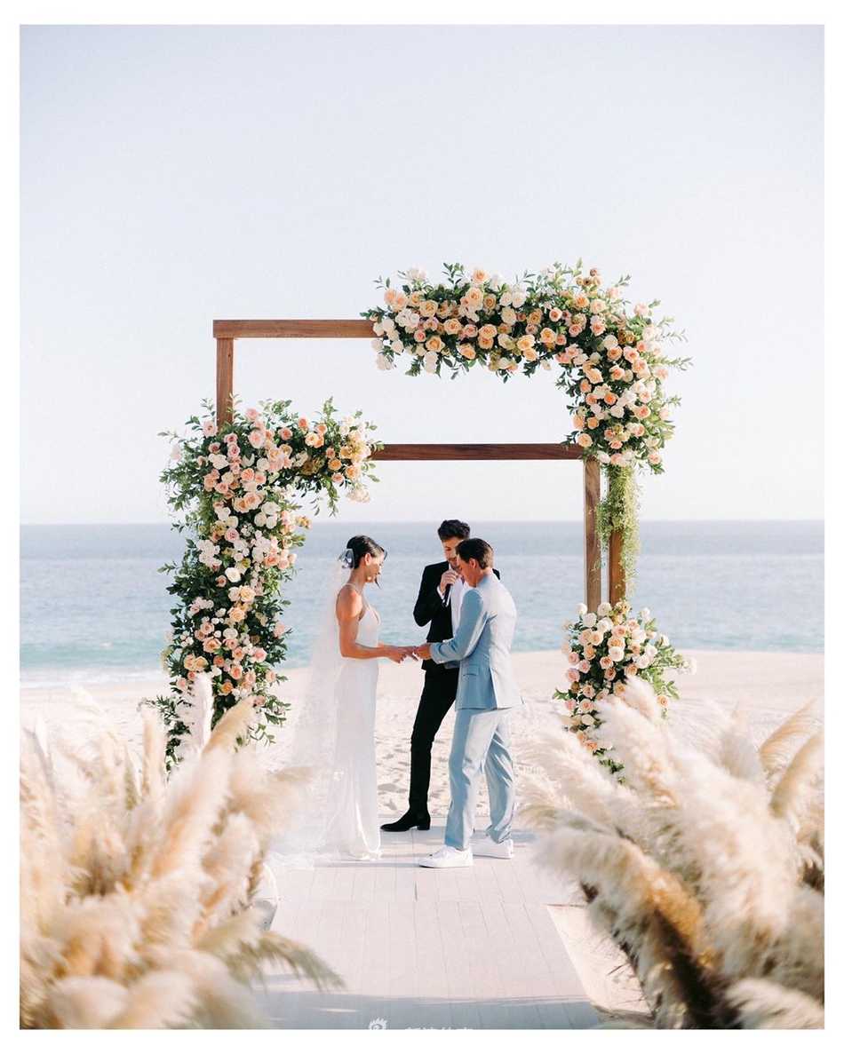 新人在沙滩上浪漫起舞，斯托克的婚纱裙摆随风轻扬，福勒揽着妻子的腰肢，两人笑容灿烂，仿佛整个世界只剩下此刻的欢愉与甜蜜