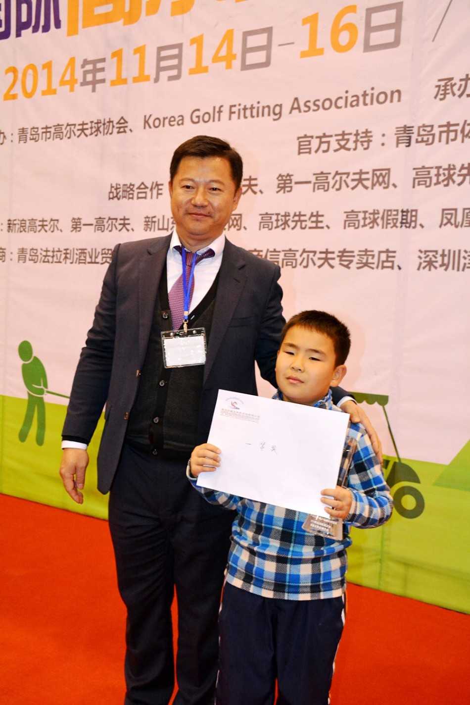 一名小球员正全神贯注地俯身观察推杆线路，眼神锐利而坚定，手中的推杆稳稳握紧。