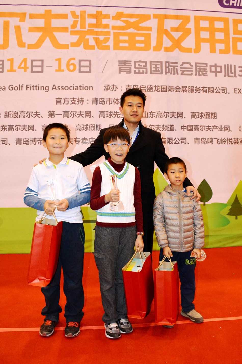 赛事承办方代表与小球手亲切互动，面带赞许的微笑，背景是广阔的球场，寓意着运动未来的无限可能。