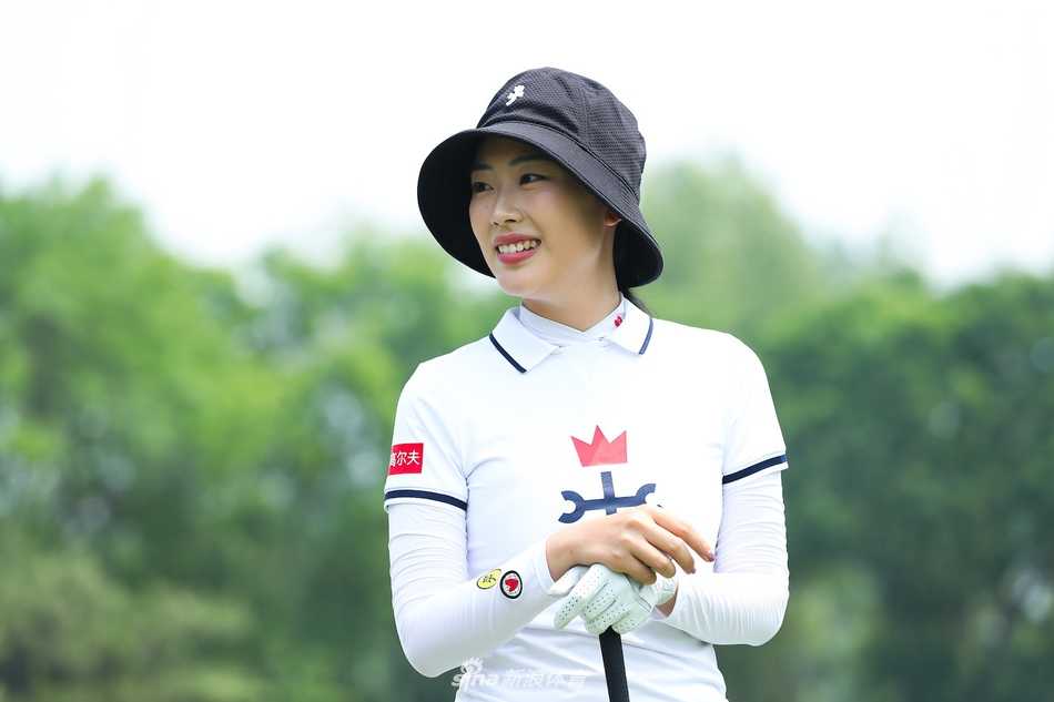 殷若宁全神贯注地准备推杆，果岭的线条与她沉稳的姿态形成和谐画面