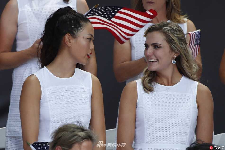 美国队队长朱莉·英科斯特在聚光灯下高高举起索尔海姆杯奖杯，神情庄重而骄傲，预示着对卫冕的坚定决心。