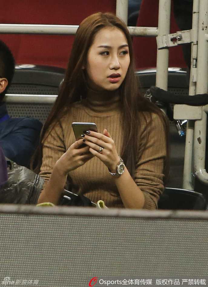 在比赛胶着的时刻，陈露紧盯着赛场上的动向，眼神中流露出一丝紧张与期待，双手轻轻合十，仿佛在为丈夫和北京队的每一次进攻默默祈祷。
