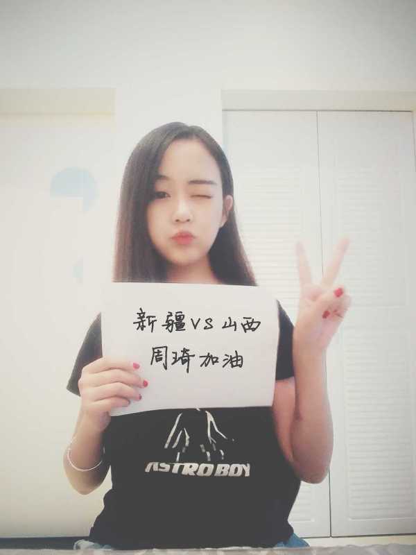 一位戴着眼镜的文静女球迷，在喧嚣的球馆中显得格外专注，她默默支持着场上的球员，或许心中正在预告着接下来的精彩赛况。