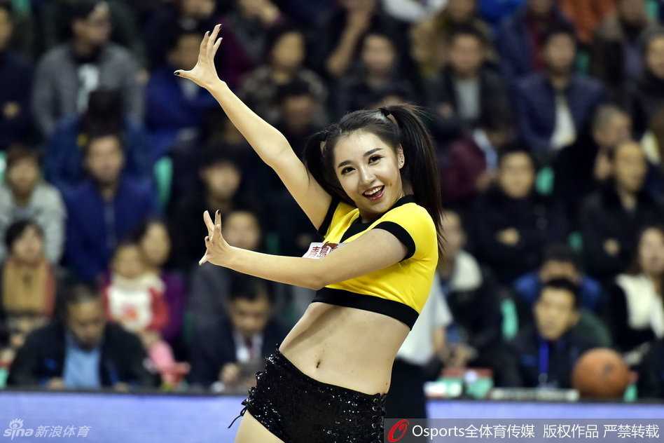 身着金色亮片短裙的篮球宝贝在赛场中央激情热舞，马尾辫随动感节奏飞扬，活力四射。