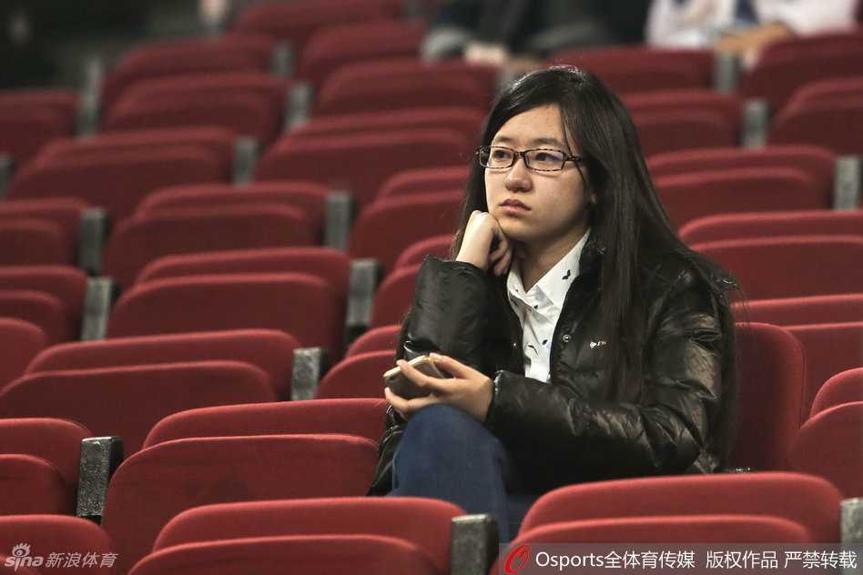 一位气质温婉的女球迷在场边为北京队的精彩配合轻轻鼓掌，她眼神中的欣喜比球场灯光还要闪亮。