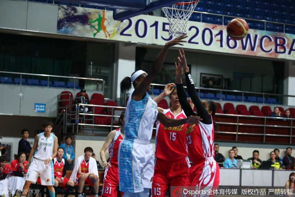 防守球员奋力跃起封盖，指尖几乎触及篮球，空中防守态势紧张