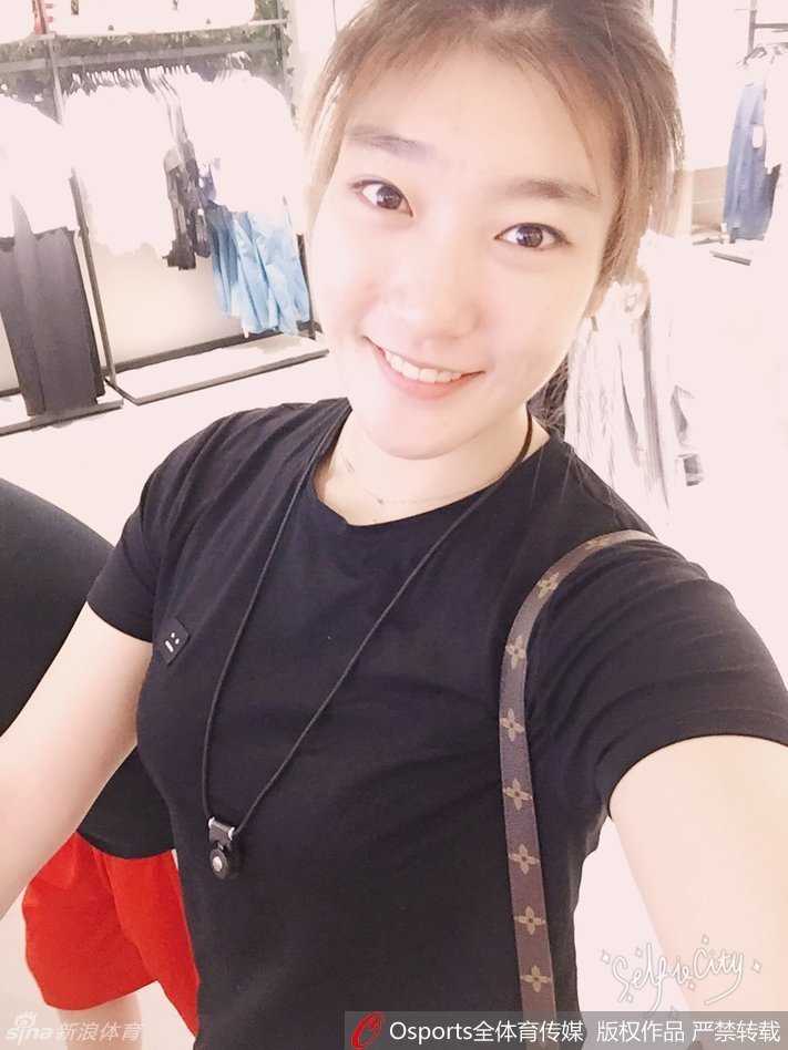 李梦身穿一件时尚的格子外套，站在街头随意一拍都颇具大片感，她单手轻抚脸颊，眼神温柔而迷人，完美展现了运动员的飒爽英姿与女性的柔美气质。