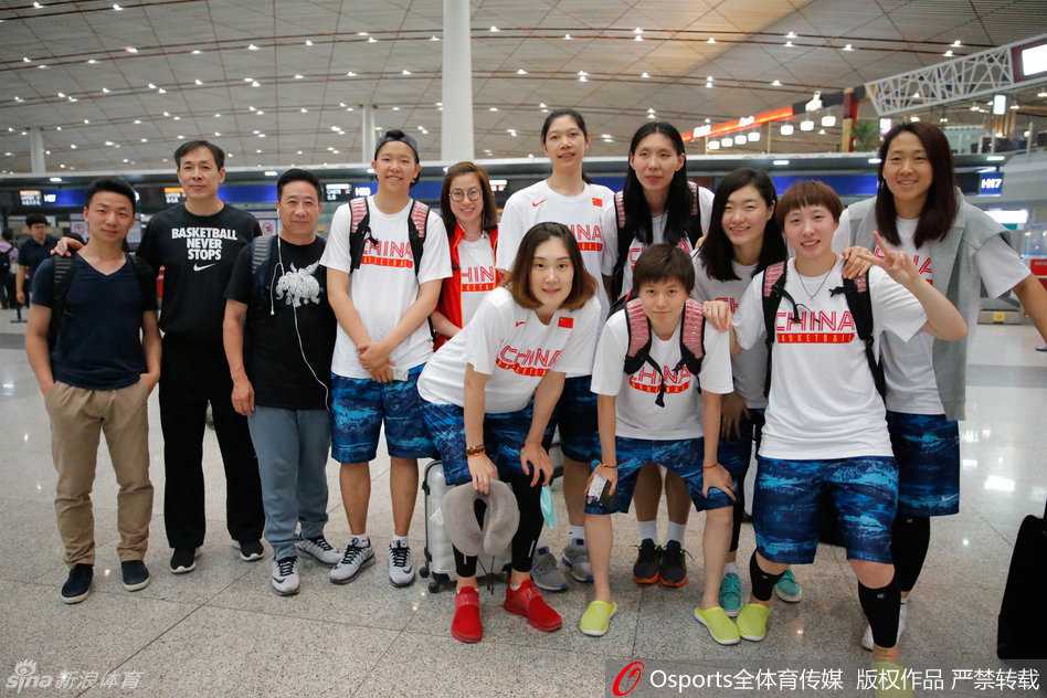 中国女篮全体将士在出征前合影，姑娘们眼神坚毅，笑容灿烂，手拉手围成一圈，凝聚着团队的力量与冲击奥运的决心。