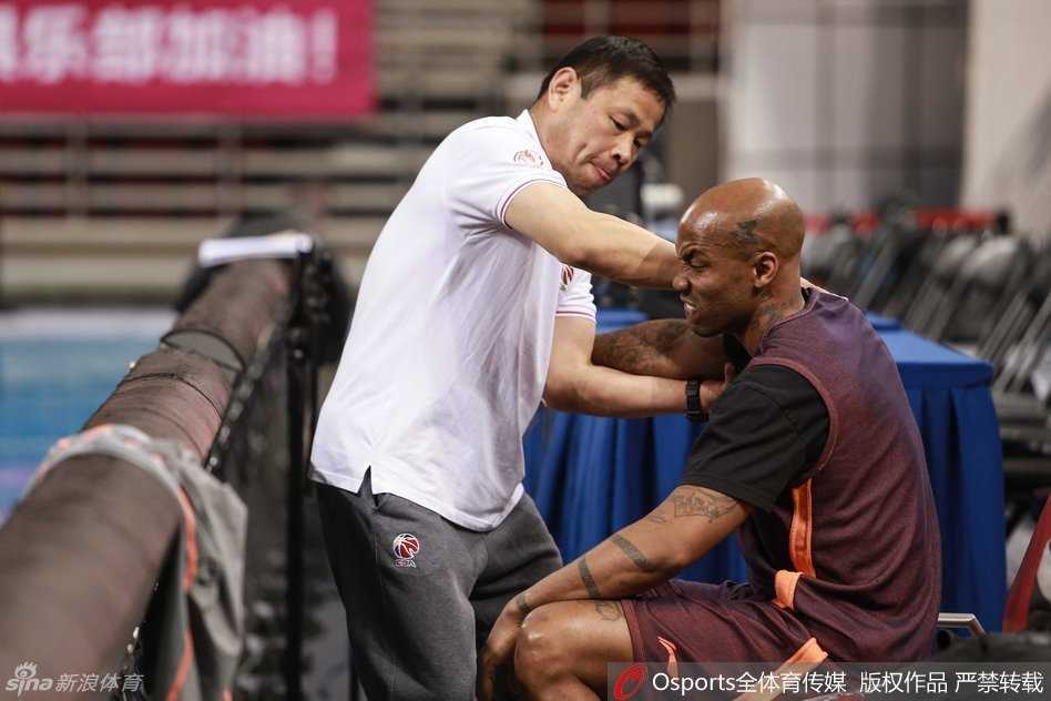 北京队功勋外援马布里在场边接受队医的细致治疗，他神情专注，眼神中透露出对胜利的渴望与坚定。