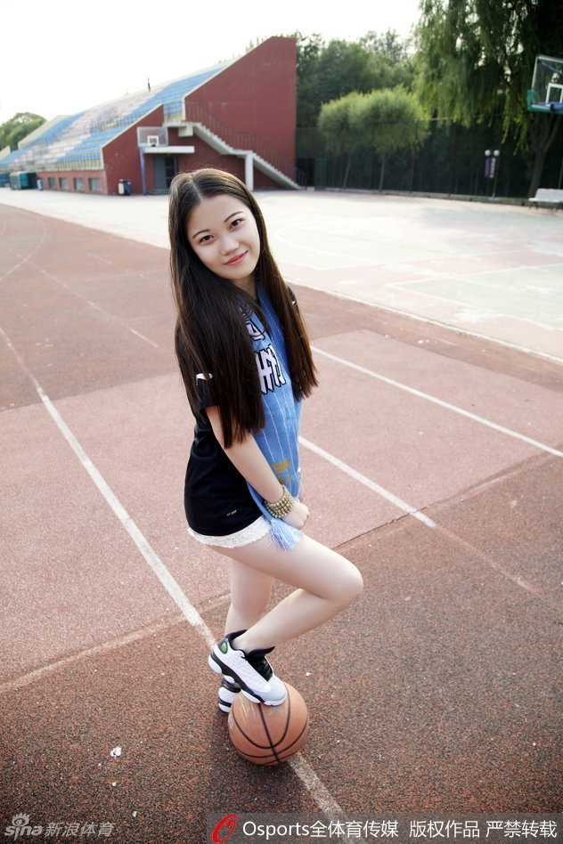 女孩在首钢篮球中心前席地而坐，长发如瀑布般散落，她温婉地看向镜头，身后仿佛能听见赛场内的呐喊，这一刻的宁静与美丽，都是为了化作赛场边最热情的声浪。
