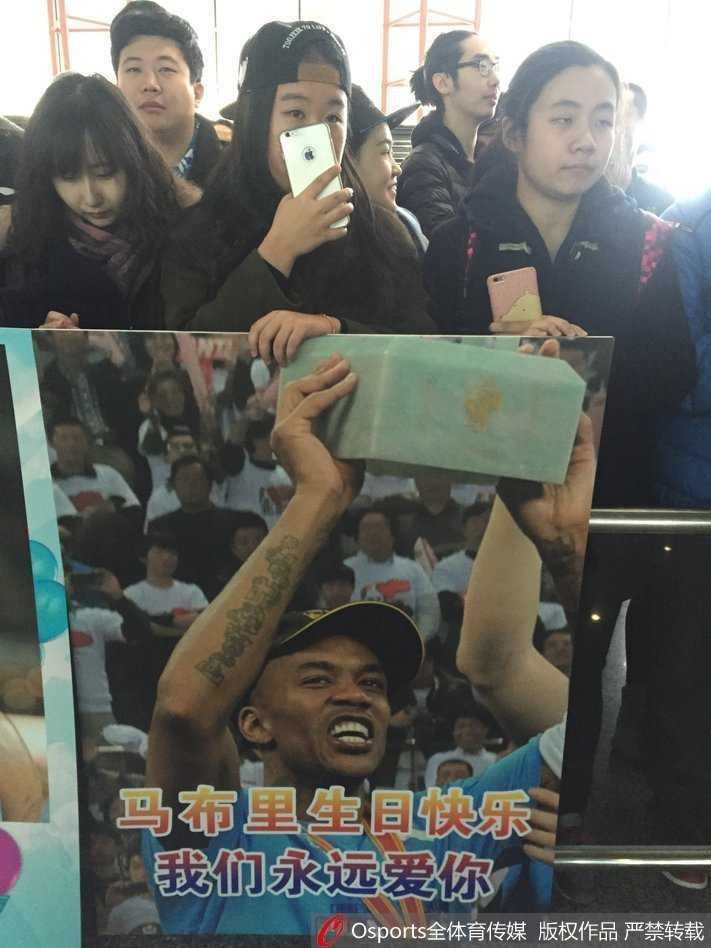 人潮涌动的首都机场到达口，二百余名北京首钢球迷身着蓝色助威服，高举欢迎标语，目光齐聚出口，只为迎接他们心中归来的英雄。