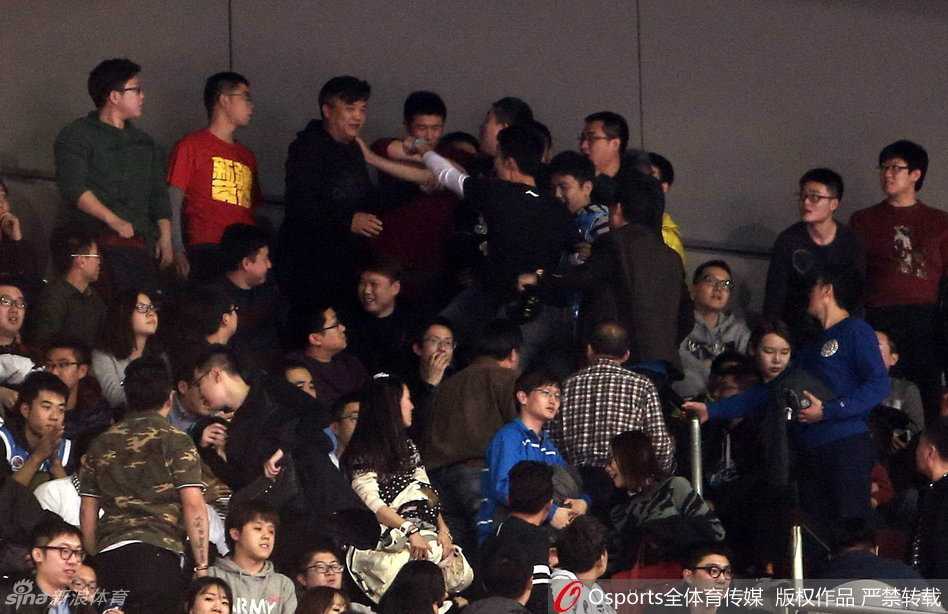 一名身着灰色安保制服的工作人员在混乱中面容严峻，他张开双臂试图拦住身后汹涌的人群，而在他的前方，是密密麻麻举起手机拍摄现场的围观群众。