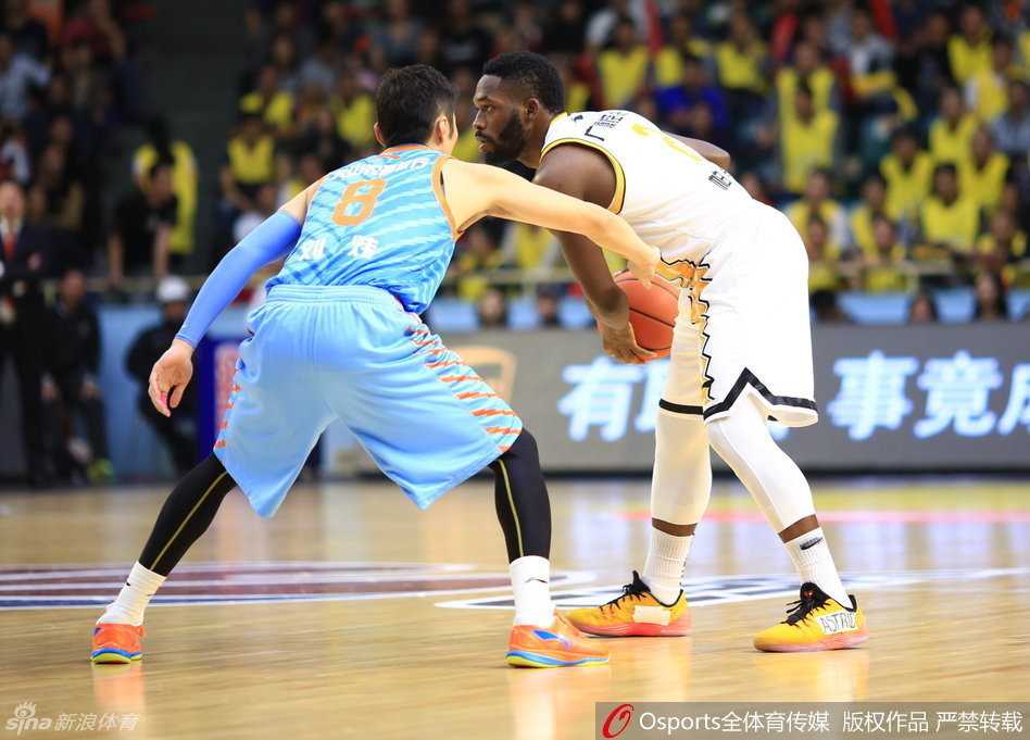 经验丰富的刘炜张开双臂，用扎实的防守脚步紧紧贴防对方持球人，眼神专注而坚定。