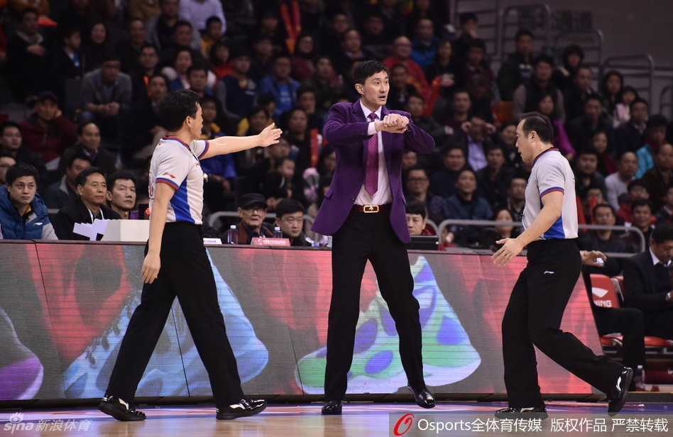 易建联在弧顶持球，冷静观察队友跑位与对手防守布局，准备发动进攻。