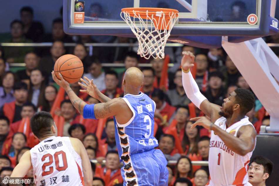 马布里运球突破，身体略微倾斜，正试图从两名防守球员的夹击中穿过，步伐灵活而坚定。