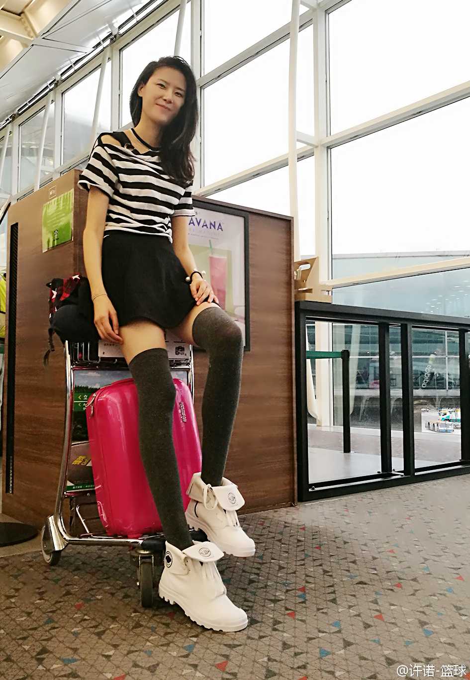 生活中的許諾身著簡約白色上衣，微笑中帶著一絲羞澀，高挑的身材與親和的氣質完美融合，彷彿鄰家那位既溫柔又耀眼的大姐姐。