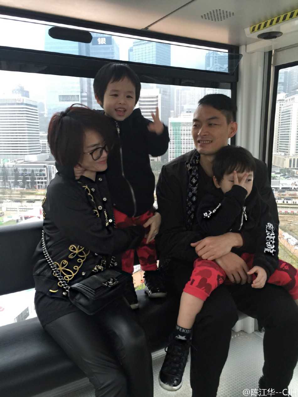 陈江华与双胞胎儿子在客厅的地毯上专心致志地组装玩具，地上散落着色彩缤纷的积木，父子三人神情专注，画面既温馨又充满童趣。