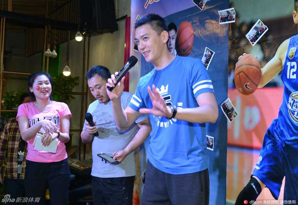 签售台前，杨鸣低头为一名小球迷手中的篮球签名，他的侧脸线条柔和，眼神里满是耐心与爱护，尽管周围人声鼎沸，他的世界此刻只为满足这个孩子的心愿而静止。